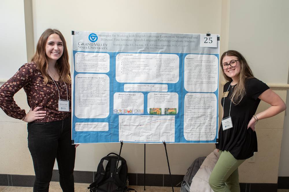 Speech-Language Pathology graduate students, Madissen Vacha (left) and Zoe King (right), standing in front of their poster.